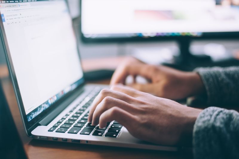 hands using an open laptop